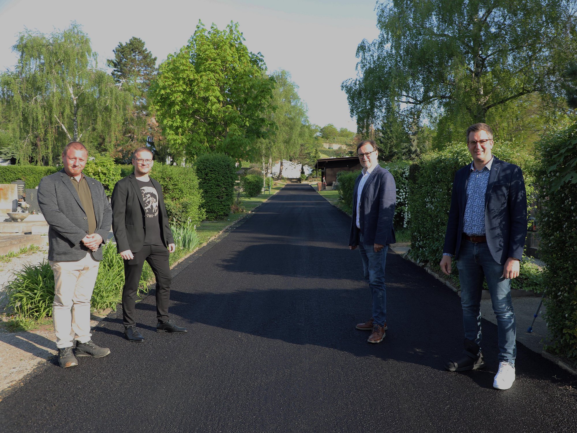 Vier Vertreter der Stadt Krems auf einen neu asphaltierten Weg am Kremser Friedhof